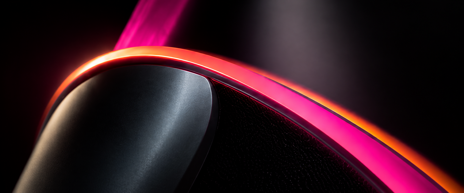 An abstract pink and orange edge crossing a dark field